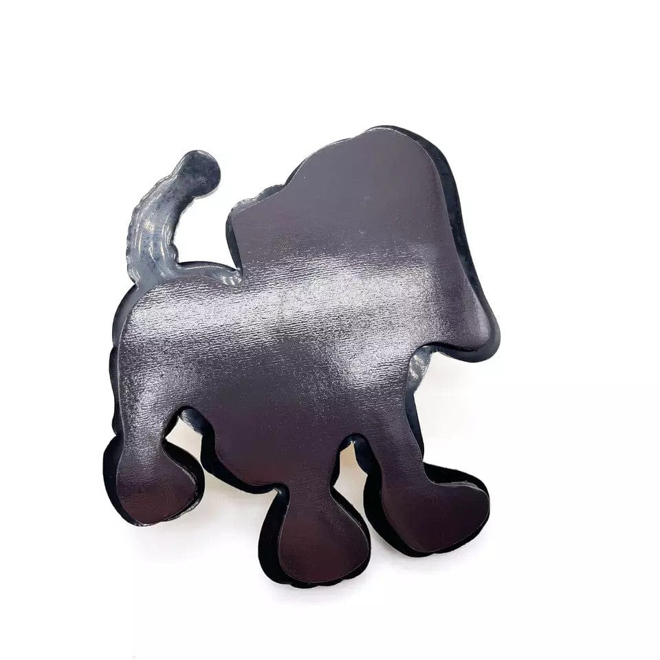 Reverse side of a character-shaped magnet showing the black magnetic backing.