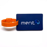 Navy blue custom bag tag with a raised white Merit logo and an orange silicone strap.