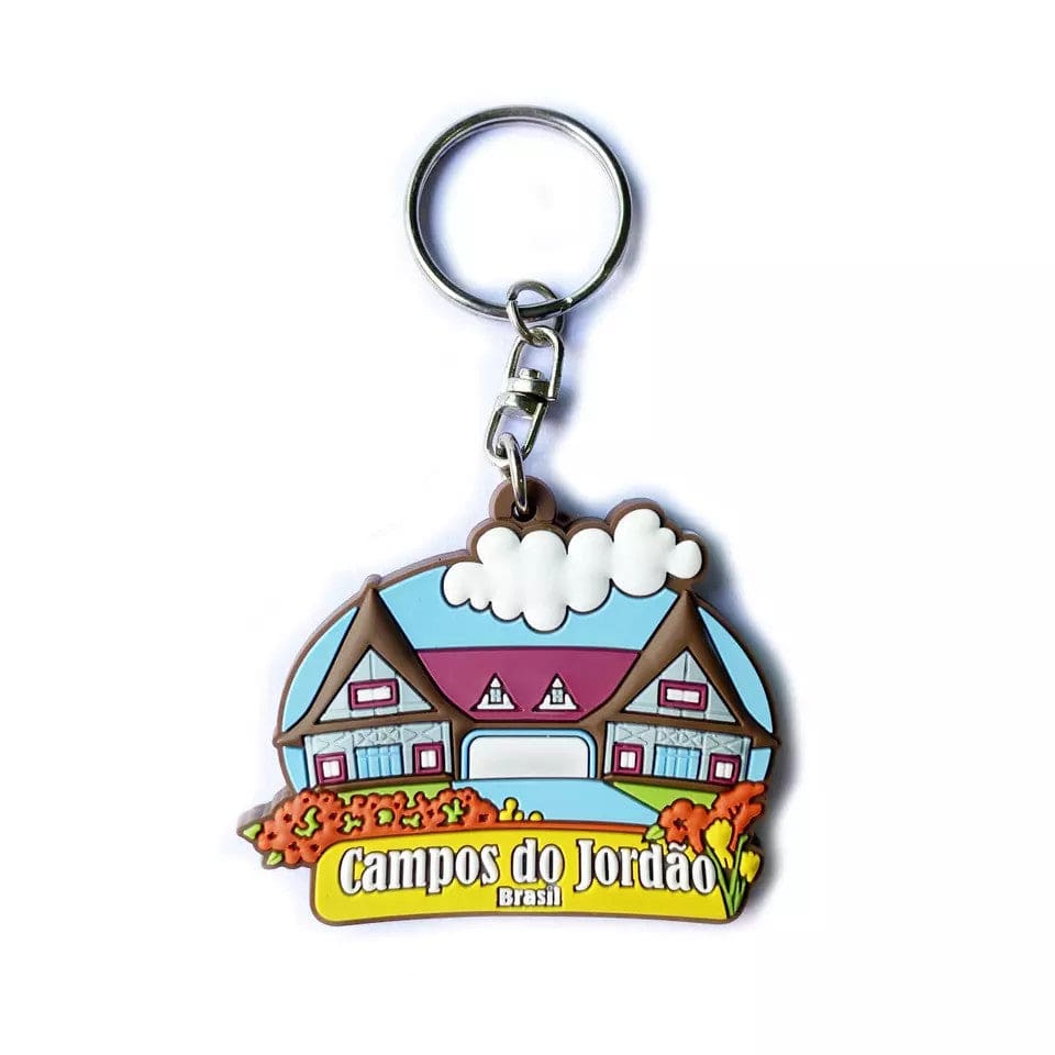 Custom souvenir keychain shaped like a chalet reading "Campos do Jordao, Brasil".