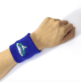 Blue custom terry cloth wristband embroidered with a Stingers team logo, shown on a wrist.