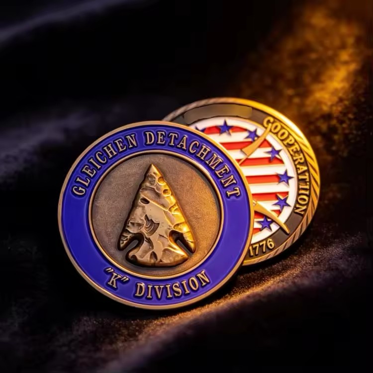 Front and back of an antique bronze custom challenge coin, with a raised arrowhead and blue enamel on one side and red, white, and blue stars and stripes on the other