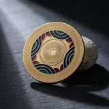 Gold custom challenge coin with navy, red, and green enamel, standing on its edge to show the raised metal design