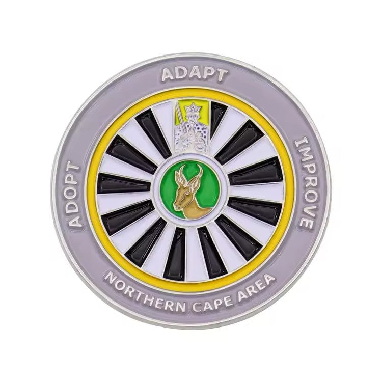 Silver custom challenge coin with black, white, yellow, and green enamel and raised lettering around the border