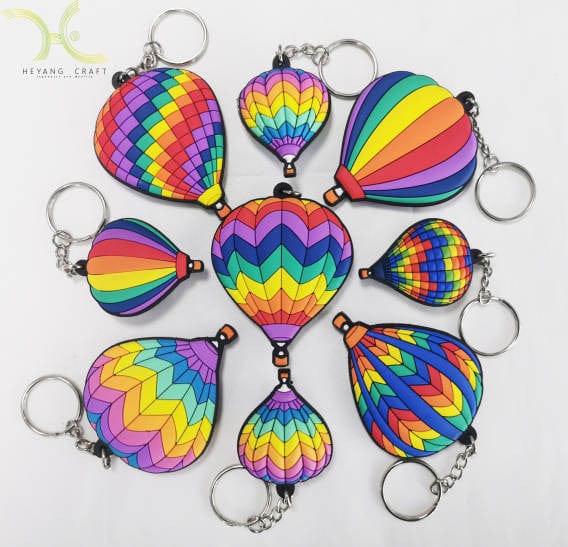 An assortment of custom hot air balloon keychains in colorful rainbow patterns.