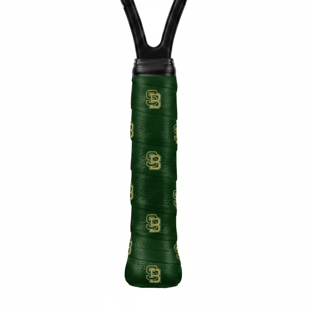 Dark green custom tennis overgrip printed with a repeating gold "SB" monogram, close-up on a racket handle.