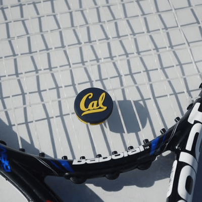 Black and white tennis racket with a custom tennis dampener.
